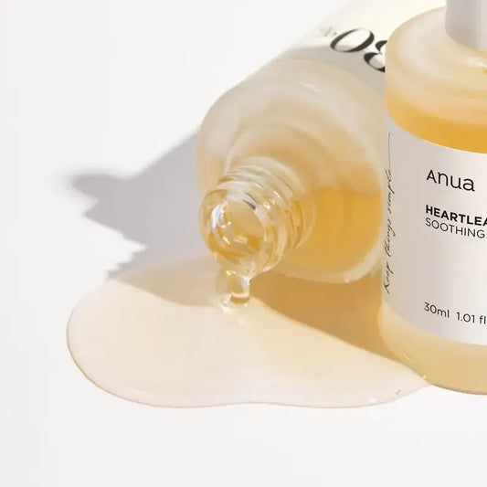 Anua Heartleaf Soothing Serum bottle with serum spilled on white background