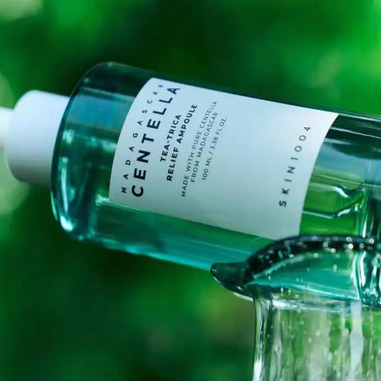 Centella ampoule serum bottle with clear liquid, nature-inspired skincare product outdoors