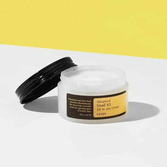 COSRX Advanced Snail 92 All in One Cream open jar on white surface with yellow background