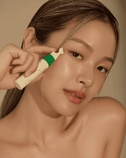 Woman applying eye cream near her eye, glowing skin, skincare routine demonstration