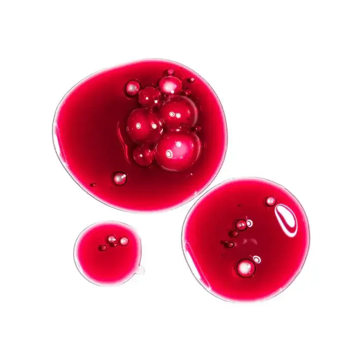 Red serum drops with bubbles on white background, skincare product texture