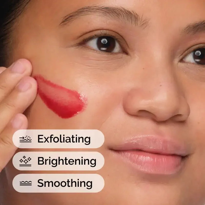 Woman applying red exfoliating gel to cheek for brightening and smoothing skincare