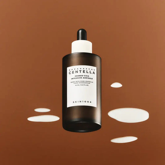 Skin1004 Centella Intensive Ampoule serum bottle with dropper and white liquid on brown background