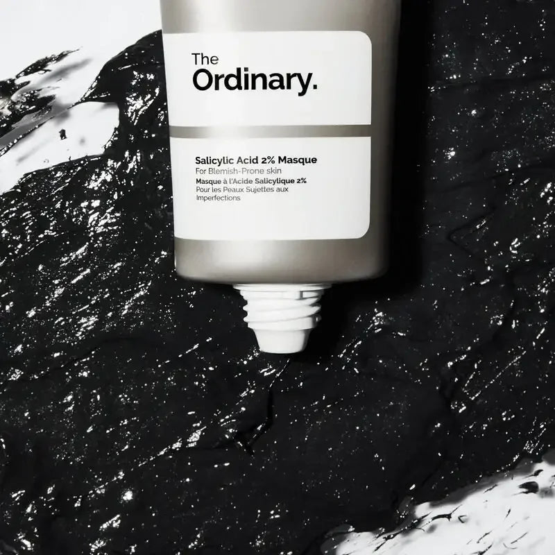 The Ordinary Salicylic Acid 2% Masque tube on black textured mask, skincare product