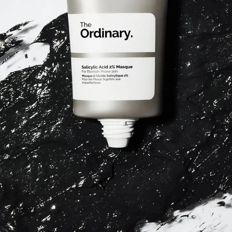The Ordinary Salicylic Acid 2% Masque tube on black textured mask, skincare product