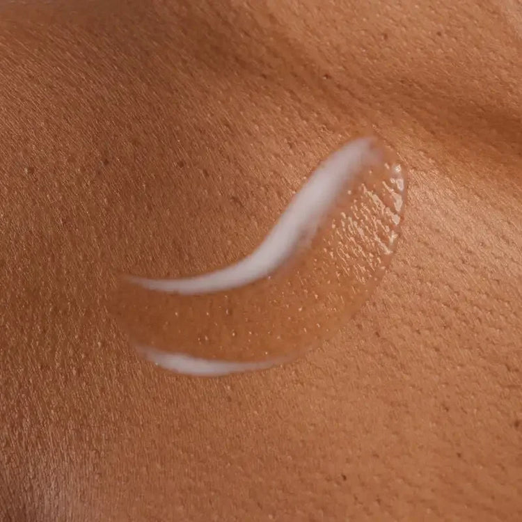 Skincare serum applied on smooth brown skin, showing hydrated texture and glossy finish