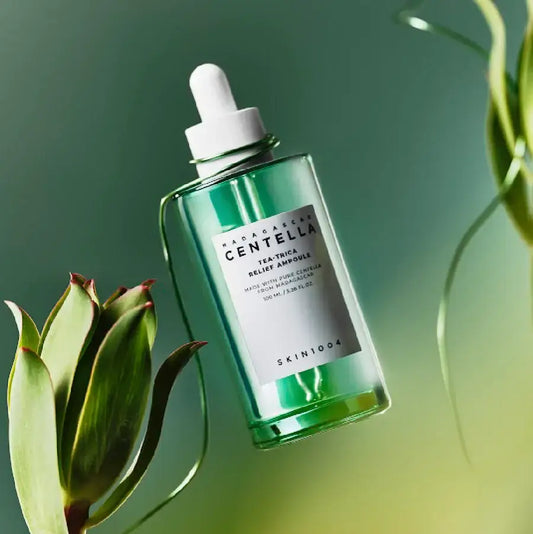 Centella tea tree ampoule serum bottle with dropper and plants on green background