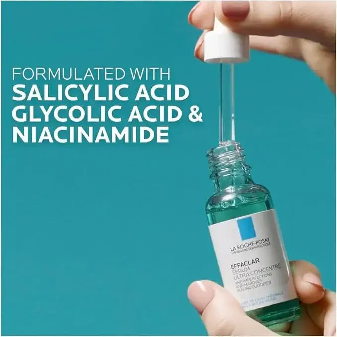 Hand holding La Roche-Posay Effaclar serum bottle with dropper, highlighting salicylic acid, glycolic acid, and niacinamide ingredients against teal background.
