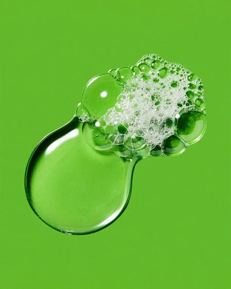 clear skincare gel with foam bubbles on green background