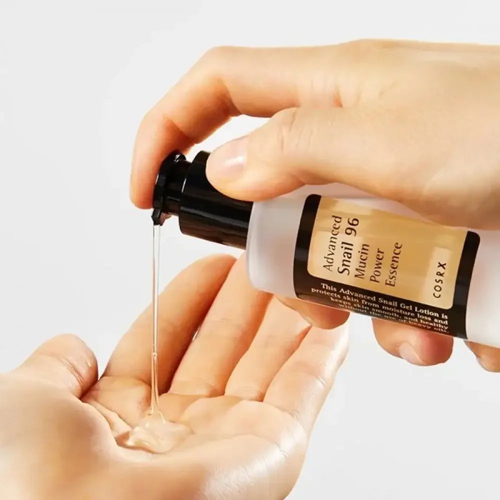 Hand dispensing COSRX Advanced Snail 96 Mucin Power Essence gel skincare into palm.
