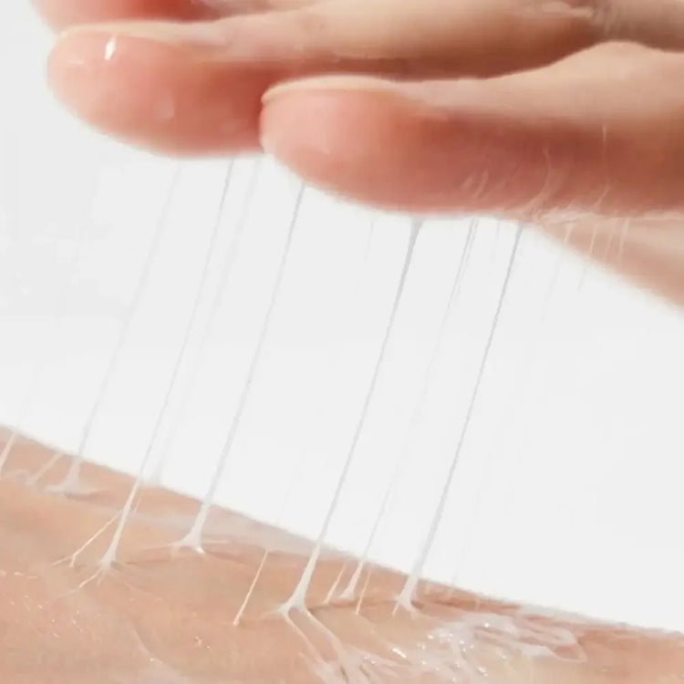 Close-up of hand applying clear, stretchy Korean skincare serum to skin