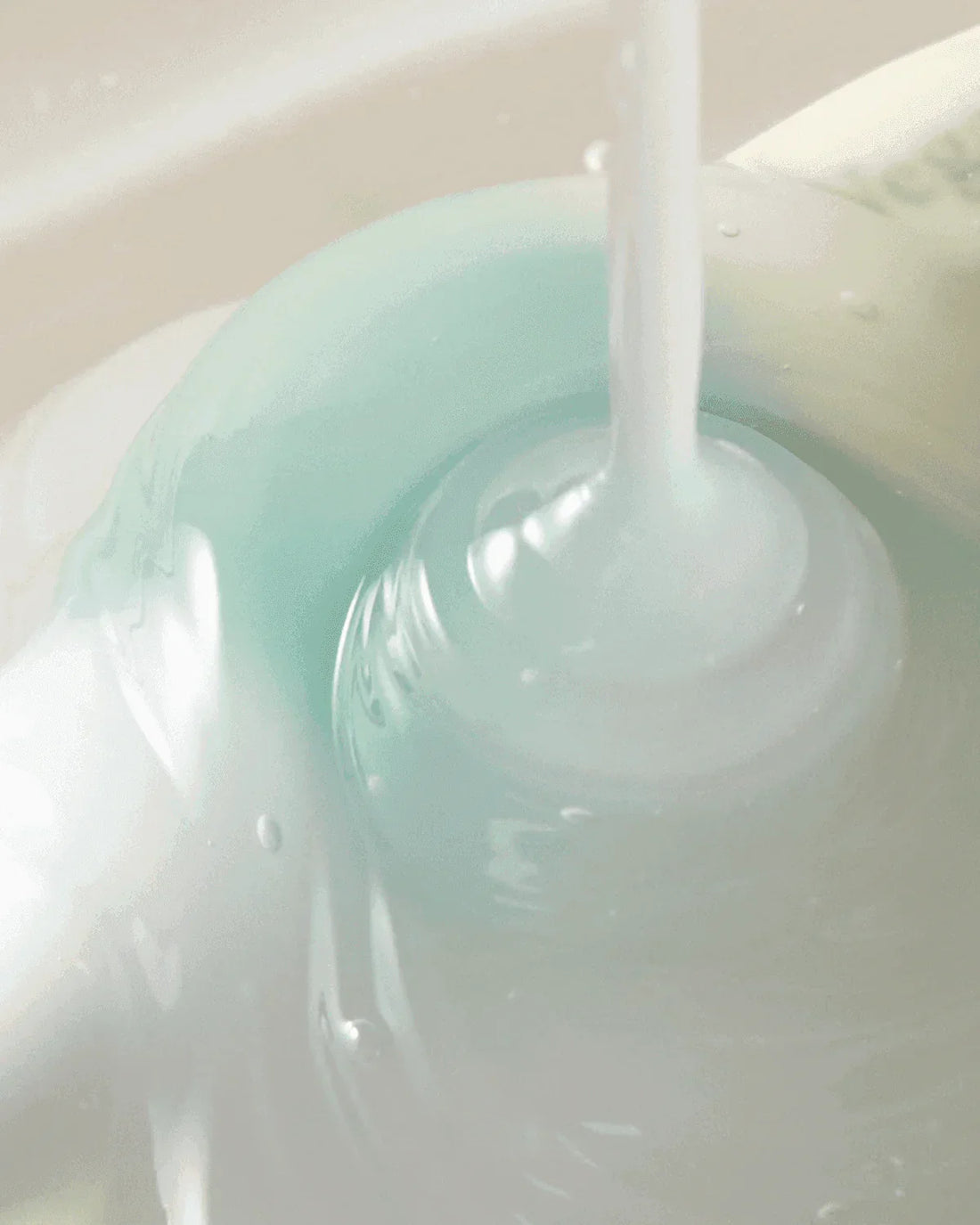 Creamy skincare cleanser with a smooth, swirling texture in pale blue and white hues