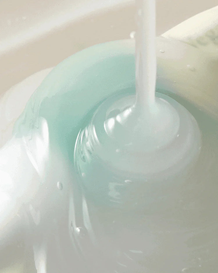 Creamy skincare cleanser with a smooth, swirling texture in pale blue and white hues