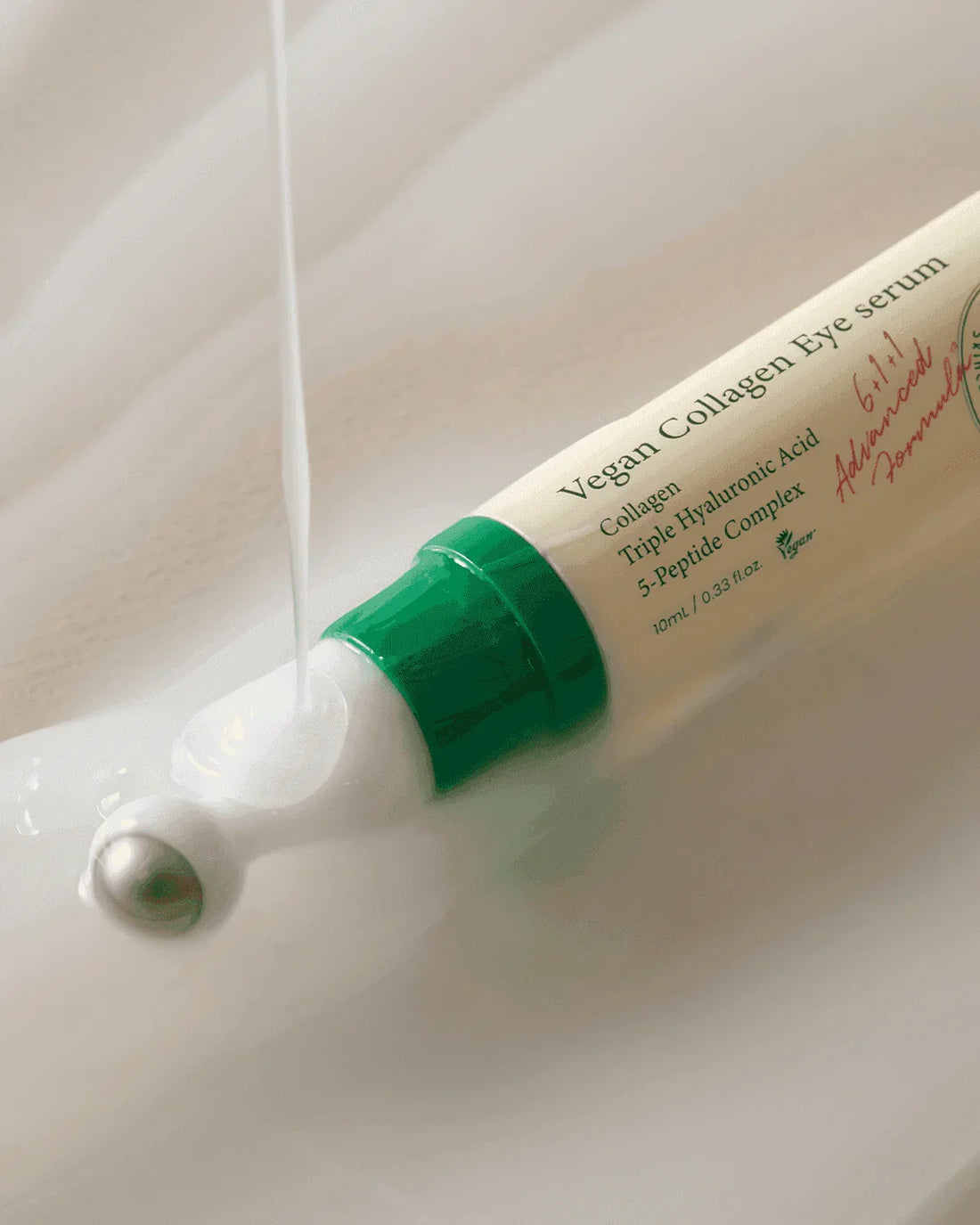 Vegan Collagen Eye Serum tube with green cap, metal roller tip, and serum texture shown