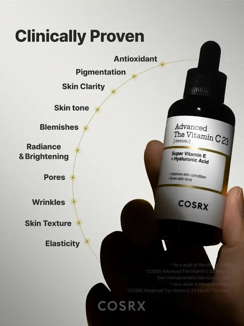 Hand holding COSRX Advanced Vitamin C 23 serum dropper bottle with skincare benefits chart.