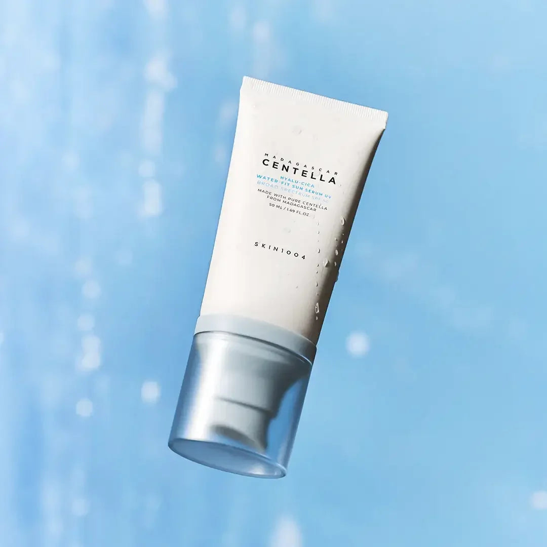 SKIN1004 Centella Hyalu-Cica Water-Fit Sun Serum 50ml tube with water droplets on blue background