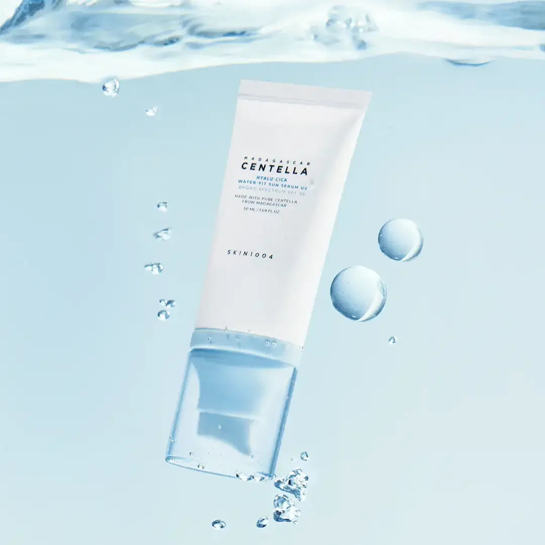 SKIN1004 Centella Hyalu-Cica Water-Fit Sun Serum tube with water droplets on blue background